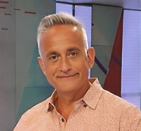 Homme souriant en chemise rose.